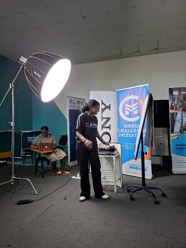 A learner practices lighting during a creative workshop